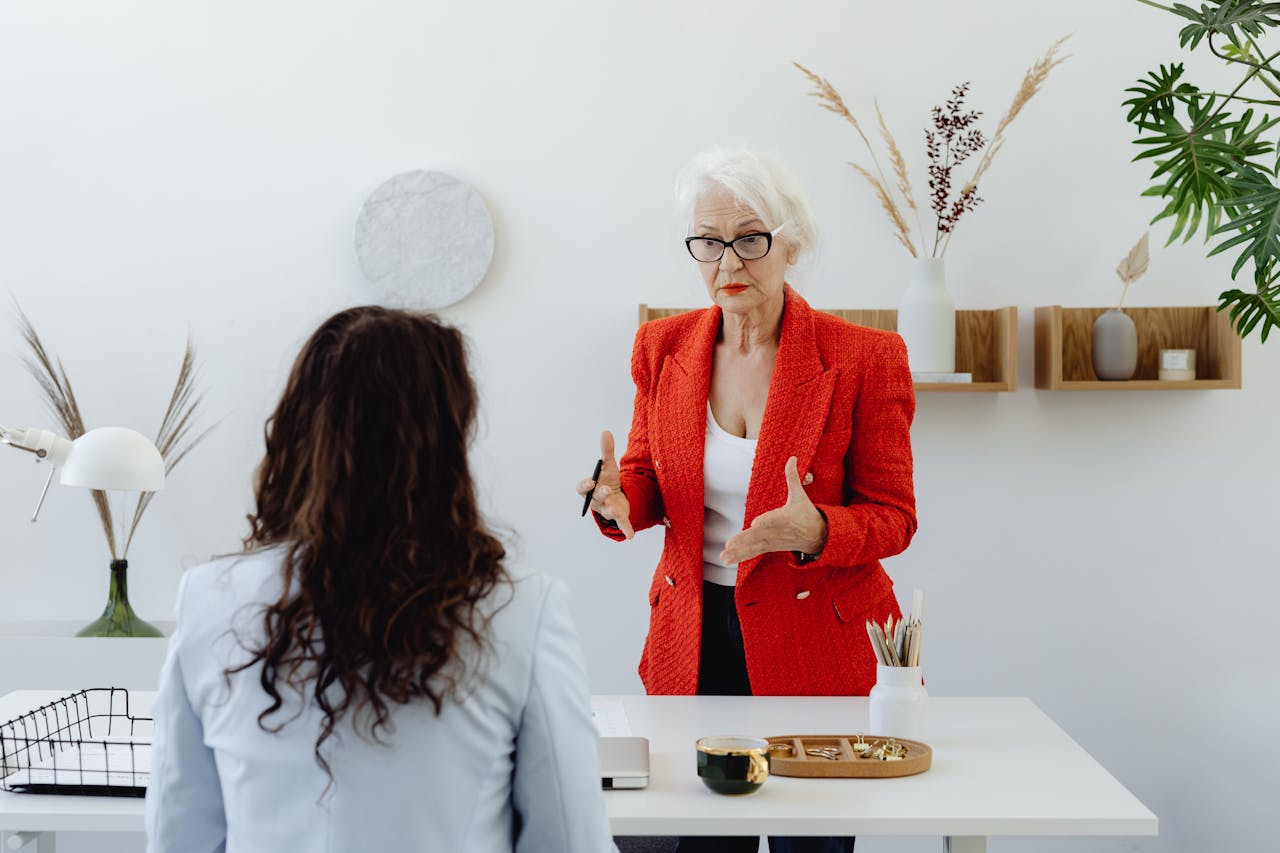 Two women having a focused discussion in a modern office environment.